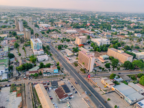 Aerial view of Ahmadu Bello Way with urban buildings lush green trees and city traffic under a clear sky in Kaduna Kaduna Nigeria. Aerial view of Ahmadu Bello Way with urban buildings lush green trees and city traffic under a clear sky in Kaduna Kaduna Nigeria.
