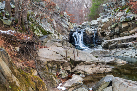 View of the cascading waterfall plunges amidst the stark rocky terrain with hints of snow clinging to the edges of the landscape Scott s Run Virginia United States. View of the cascading waterfall plunges amidst the stark rocky terrain with hints of snow clinging to the edges of the landscape Scott s Run Virginia United States.