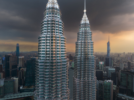 Kuala Lumpur Malaysia 11 March 2026 Aerial view of the Petronas Twin Towers against a dramatic sunset sky with dark storm clouds and the surrounding city skyline.