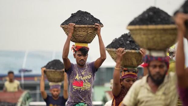 View of workers carrying coal baskets in Aminbazar Bangladesh. View of workers carrying coal baskets in Aminbazar Bangladesh.