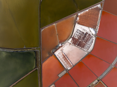 Aerial view of the colorful salt pans in Pomorie featuring geometric patterns of red orange and green water basins separated by narrow paths in Pomorie Burgas Bulgaria. Aerial view of the colorful salt pans in Pomorie featuring geometric patterns of red orange and green water basins separated by narrow paths in Pomorie Burgas Bulgaria.