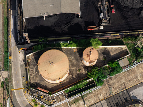 Aerial view of industrial storage tanks and coal piles at a facility in Bajos de Haina San Cristobal Provinc Dominican Republic.