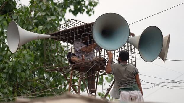 View of men installing loudspeakers in Aminbazar Bangladesh. View of men installing loudspeakers in Aminbazar Bangladesh.