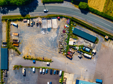 Aerial view of a storage yard in Rocroi featuring various industrial containers parked vehicles and construction materials Rocroi Grand Est France. Aerial view of a storage yard in Rocroi featuring various industrial containers parked vehicles and construction materials Rocroi Grand Est France.
