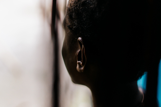 View of a person in profile with soft lighting and dark shadows in Southwest Papua Indonesia. View of a person in profile with soft lighting and dark shadows in Southwest Papua Indonesia.