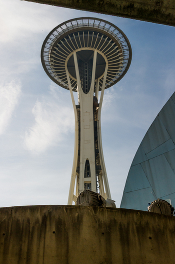 View of the Space Needle tower rising against a blue sky with clouds seen from the base in Seattle Washington United States.