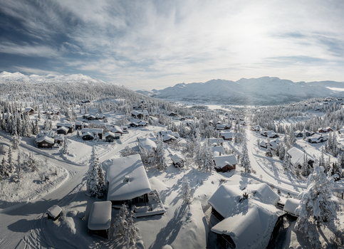 Aerial view of Gaustablikk Fjellresort with snow covered wooden cabins nestled among pine trees and mountains in Rjukan Telemark Norway. Aerial view of Gaustablikk Fjellresort with snow covered wooden cabins nestled among pine trees and mountains in Rjukan Telemark Norway.