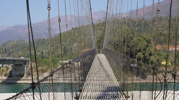 View of a long suspension bridge over a river Nepal.