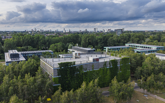 Aerial view of High Tech Campus Eindhoven with modern buildings green walls and surrounding woodland under a cloudy sky Eindhoven Noord Brabant Netherlands. Aerial view of High Tech Campus Eindhoven with modern buildings green walls and surrounding woodland under a cloudy sky Eindhoven Noord Brabant Netherlands.
