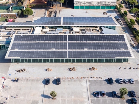 Aerial view of solar panel arrays installed on the roof of a modern building with a parking lot in the foreground in Cascais Lisboa Portugal. Aerial view of solar panel arrays installed on the roof of a modern building with a parking lot in the foreground in Cascais Lisboa Portugal.