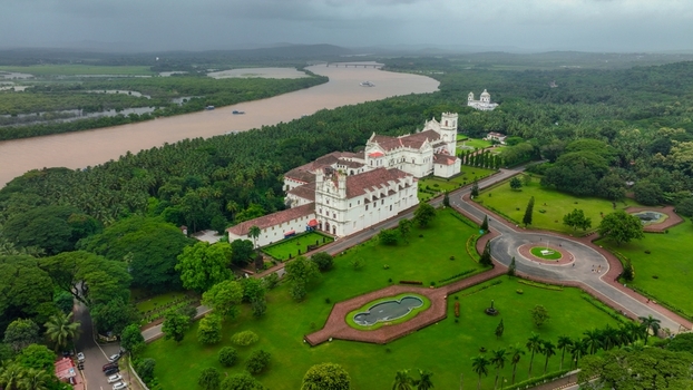 Aerial view of the Church of St. Francis of Assisi surrounded by lush green lawns palm trees and the Mandovi River in Old Goa Goa India. Aerial view of the Church of St. Francis of Assisi surrounded by lush green lawns palm trees and the Mandovi River in Old Goa Goa India.
