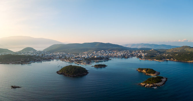 Aerial view of the coastal town of Ksamil and its small islands surrounded by the calm blue waters of the Ionian Sea under a clear sky in Ksamil Vlore County Albania. Aerial view of the coastal town of Ksamil and its small islands surrounded by the calm blue waters of the Ionian Sea under a clear sky in Ksamil Vlore County Albania.