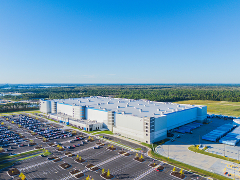 Wilmington United States 27 September 2026 Aerial view of Amazon Robotics Fulfillment Center ILM1 with its large white roof parking lot and surrounding forest. Wilmington United States 27 September 2026 Aerial view of Amazon Robotics Fulfillment Center ILM1 with its large white roof parking lot and surrounding forest.