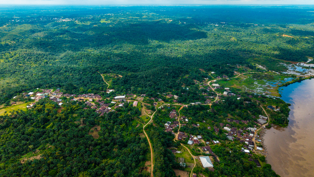 Aerial view of the town of Itu nestled within a dense tropical forest landscape with a winding river and small village buildings in Itu Akwa Ibom Nigeria. Aerial view of the town of Itu nestled within a dense tropical forest landscape with a winding river and small village buildings in Itu Akwa Ibom Nigeria.