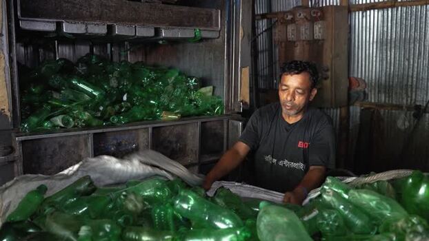 View of a worker recycling green plastic bottles in Bogura Bangladesh. View of a worker recycling green plastic bottles in Bogura Bangladesh.