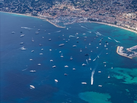 Aerial view of numerous yachts and boats anchored in the bay of Cannes with the coastal city skyline in the background in Cannes Provence Alpes Cote d Azur France. Aerial view of numerous yachts and boats anchored in the bay of Cannes with the coastal city skyline in the background in Cannes Provence Alpes Cote d Azur France.