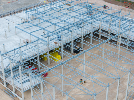 Aerial view of a steel frame construction site with concrete flooring and yellow building materials in Riga Latvia. Aerial view of a steel frame construction site with concrete flooring and yellow building materials in Riga Latvia.