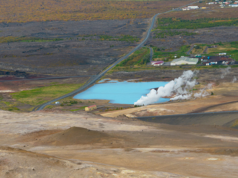 Aerial view of the contrasting pale blue lake amidst the dark rugged terrain with steam rising near the village Reykjahl&iacute;&eth; &THORN;ingeyjarsveit Iceland.