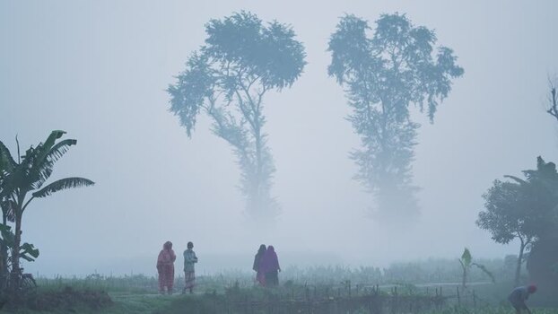 View of people walking in a foggy rural landscape Bangladesh.