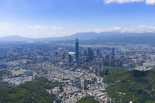 Aerial view of Taipei 101 skyscraper rising above the dense urban landscape of Taipei surrounded by lush green hills under a clear blue sky in Taipei Taipei City Taiwan. Aerial view of Taipei 101 skyscraper rising above the dense urban landscape of Taipei surrounded by lush green hills under a clear blue sky in Taipei Taipei City Taiwan.