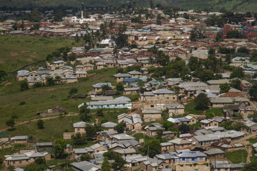 View of a densely populated town with small houses corrugated metal roofs and a white mosque nestled among green hills and lush vegetation Tiwi Wilaya ya Kwale Kenya. View of a densely populated town with small houses corrugated metal roofs and a white mosque nestled among green hills and lush vegetation Tiwi Wilaya ya Kwale Kenya.