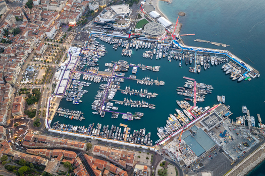 Aerial view of the marina in Cannes filled with luxury yachts and boats surrounded by historic urban architecture and coastal landscape of Cannes Provence Alpes Cote d Azur France. Aerial view of the marina in Cannes filled with luxury yachts and boats surrounded by historic urban architecture and coastal landscape of Cannes Provence Alpes Cote d Azur France.