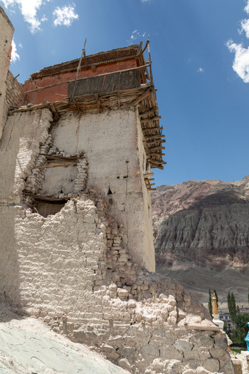 View of Charasa Gonpa an ancient Buddhist monastery with weathered mud brick walls and wooden balconies set against a rugged mountain landscape in Charasa Ladakh India.