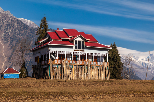 View of a traditional house with a red roof and wooden balcony nestled in the scenic mountains of Arang Kel Azad Kashmir Pakistan. View of a traditional house with a red roof and wooden balcony nestled in the scenic mountains of Arang Kel Azad Kashmir Pakistan.