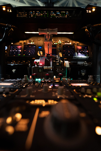 View of the illuminated cockpit of a Boeing 737 800 at Hannover Airport with glowing flight instrument panels and throttle controls in Langenhagen Niedersachsen Germany. View of the illuminated cockpit of a Boeing 737 800 at Hannover Airport with glowing flight instrument panels and throttle controls in Langenhagen Niedersachsen Germany.