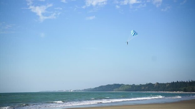 View of a person parasailing over the beach Bangladesh.