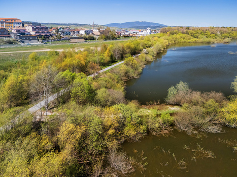 Aerial view of Oravska priehrada reservoir with lush spring trees and a walking path along the shore in Namestovo Zilinsky kraj Slovakia. Aerial view of Oravska priehrada reservoir with lush spring trees and a walking path along the shore in Namestovo Zilinsky kraj Slovakia.