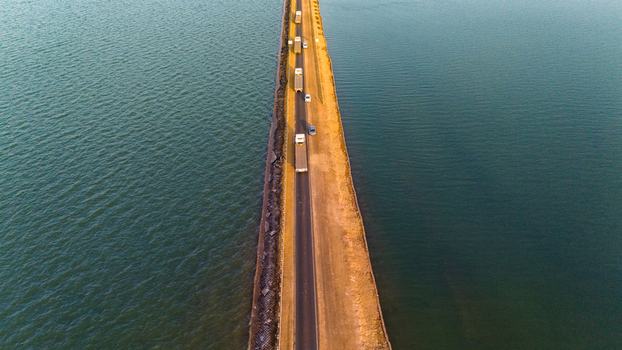 Aerial view of the Road to Heaven a long straight road stretching through the salt flats of the Rann of Kutch with vehicles driving along the causeway in Bhuj Gujarat India. Aerial view of the Road to Heaven a long straight road stretching through the salt flats of the Rann of Kutch with vehicles driving along the causeway in Bhuj Gujarat India.