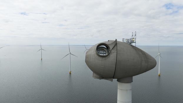 Aerial view of an offshore wind turbine nacelle with other turbines in the background over the water in Espel Flevoland Netherlands. Aerial view of an offshore wind turbine nacelle with other turbines in the background over the water in Espel Flevoland Netherlands.