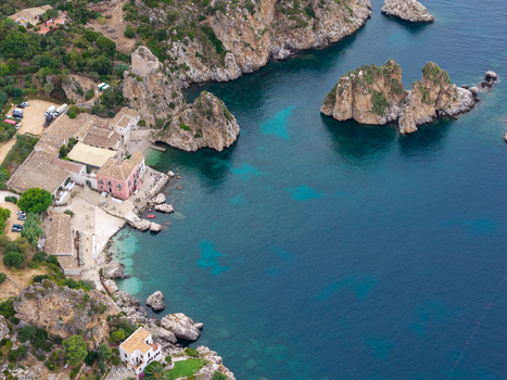 Aerial view of Riserva Naturale Orientata dello Zingaro and the historic Tonnara di Scopello with rocky cliffs turquoise sea and Mediterranean vegetation in San Vito Lo Capo Sicilia Italy. Aerial view of Riserva Naturale Orientata dello Zingaro and the historic Tonnara di Scopello with rocky cliffs turquoise sea and Mediterranean vegetation in San Vito Lo Capo Sicilia Italy.