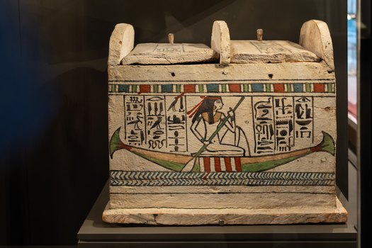 Giza Egypt 16 May 2026 View of an ancient Egyptian painted wooden chest featuring hieroglyphs and a figure in a boat on display at the Grand Egyptian Museum.
