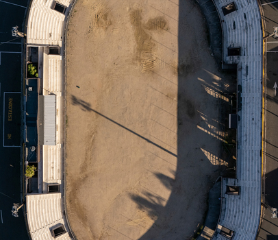 Aerial view of the Feria Ganadera featuring an oval track and tiered seating with long shadows cast by stadium lights in Santo Domingo Distrito Nacional Dominican Republic. Aerial view of the Feria Ganadera featuring an oval track and tiered seating with long shadows cast by stadium lights in Santo Domingo Distrito Nacional Dominican Republic.