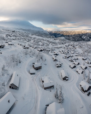 Aerial view of Gaustablikk Fjellresort featuring snow covered cabins and winding roads nestled in the mountains of Rjukan Telemark Norway. Aerial view of Gaustablikk Fjellresort featuring snow covered cabins and winding roads nestled in the mountains of Rjukan Telemark Norway.