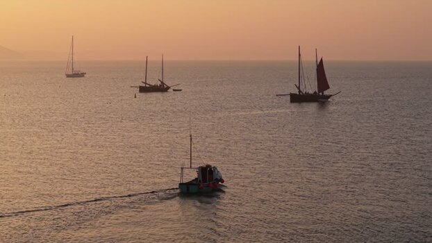 Aerial view of fishing boats on the sea at sunset United Kingdom. Aerial view of fishing boats on the sea at sunset United Kingdom.