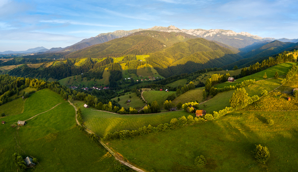 Brasov Brasov Romania 21 September 2026 Aerial view of rolling green hills and rural houses nestled in the Carpathian Mountains under a clear blue sky during the golden hour. Brasov Brasov Romania 21 September 2026 Aerial view of rolling green hills and rural houses nestled in the Carpathian Mountains under a clear blue sky during the golden hour.