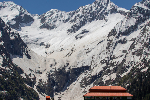 View of the Jahaz Banda Alpine Rest House nestled against the backdrop of towering snow capped mountains in the Kumrat Valley Khyber Pakhtunkhwa Pakistan. View of the Jahaz Banda Alpine Rest House nestled against the backdrop of towering snow capped mountains in the Kumrat Valley Khyber Pakhtunkhwa Pakistan.