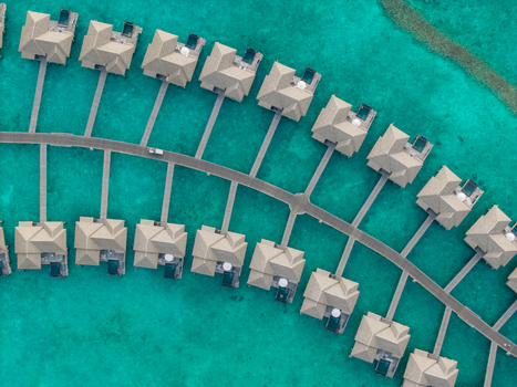 Aerial view of numerous overwater bungalows their light roofs sharply contrasted by the dazzling turquoise sea Hoarafushi Thiladhunmathee Uthuruburi Maldives. Aerial view of numerous overwater bungalows their light roofs sharply contrasted by the dazzling turquoise sea Hoarafushi Thiladhunmathee Uthuruburi Maldives.