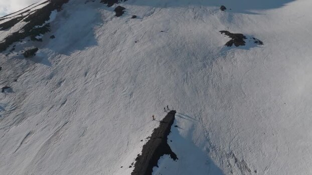 Aerial view of hikers on a snowy volcanic ridge near Rifugio Sapienza Italy. Aerial view of hikers on a snowy volcanic ridge near Rifugio Sapienza Italy.