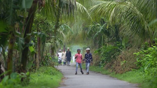 View of children walking on a rural road in Bogura Bangladesh. View of children walking on a rural road in Bogura Bangladesh.