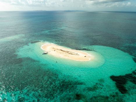 Aerial view of Naked Island surrounded by turquoise coral reefs and clear blue water in Siargao Philippines. Aerial view of Naked Island surrounded by turquoise coral reefs and clear blue water in Siargao Philippines.