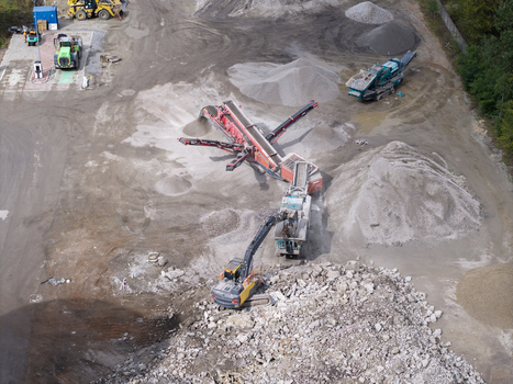 Aerial view of demolition and dismantling works with heavy machinery including crushers and excavators processing construction debris in Krakow Lesser Poland Voivode Poland.