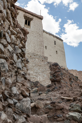 View of the historic Charasa Gonpa monastery featuring weathered stone walls and traditional architecture set against a bright blue sky in Charasa Ladakh India.