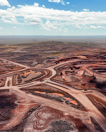 Aerial view of an extensive road network winding through a vast open cast mining operation with red earth and heavy machinery tracks in Mahikeng North West South Africa. Aerial view of an extensive road network winding through a vast open cast mining operation with red earth and heavy machinery tracks in Mahikeng North West South Africa.