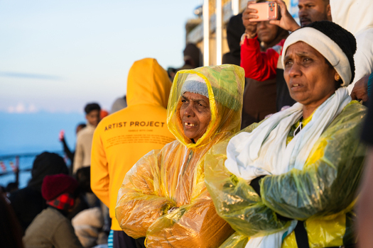 Ratnapura Sri Lanka 23 February 2026 View of pilgrims wearing raincoats and warm clothing waiting at the summit of Adam s Peak during the early morning hours.