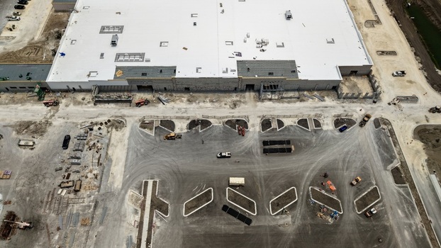 Aerial view of Foundry Lane construction site featuring a large industrial building with a white roof and a developing parking area World Golf Village Florida United States.