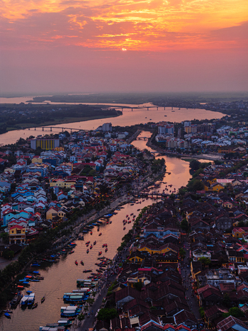 Aerial view of the historic town of Hoi An with traditional boats on the river at sunset Vietnam. Aerial view of the historic town of Hoi An with traditional boats on the river at sunset Vietnam.